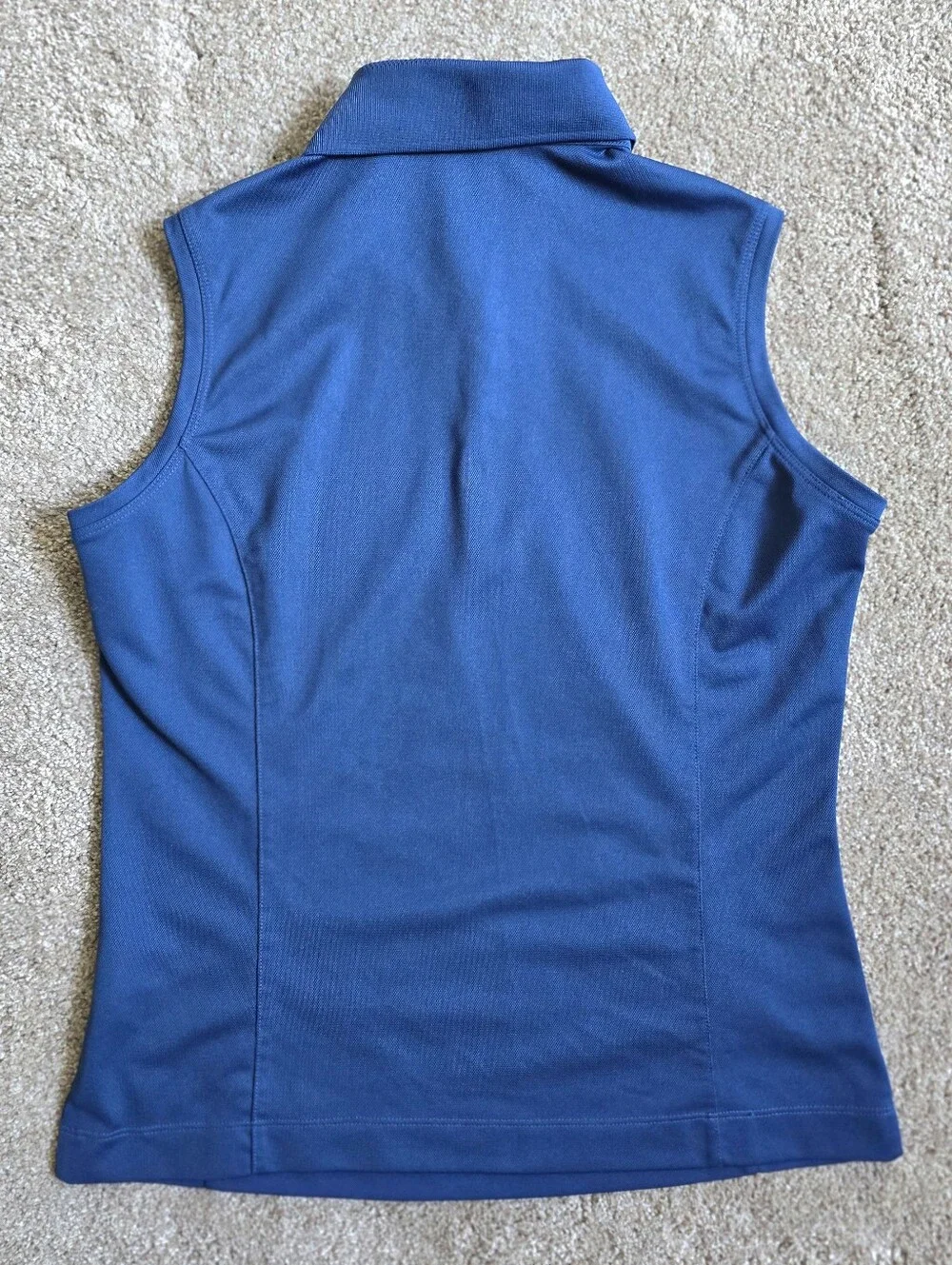 Royal blue sleeveless Nike Golf polo featuring a white-buttone